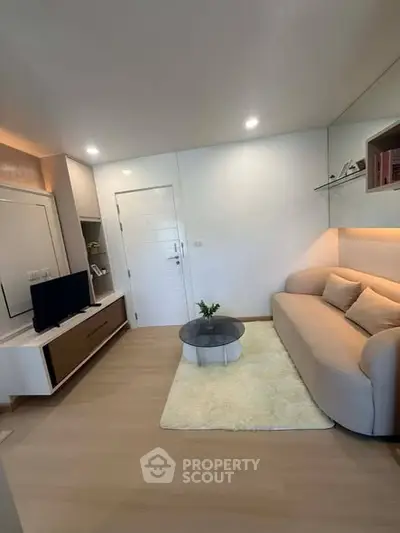 Modern living room with cozy sofa and sleek TV unit in a stylish apartment.