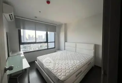 Spacious bedroom with city view, featuring a large bed and modern decor.