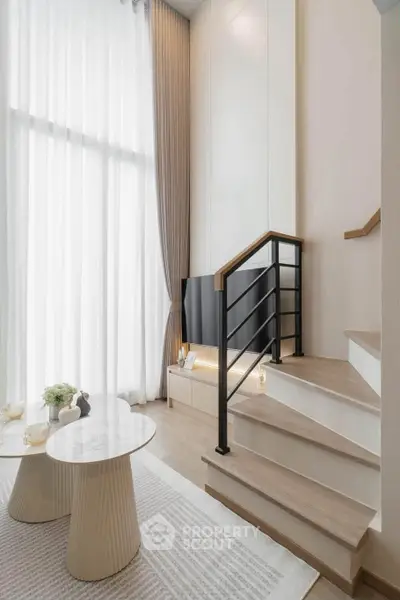 Modern duplex living room with high ceilings and elegant staircase