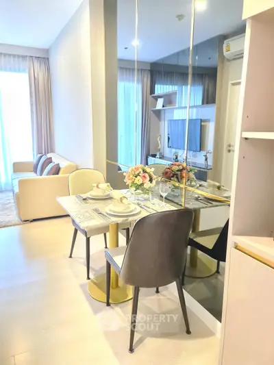 Modern living room with dining area, elegant decor, and large mirror enhancing space.