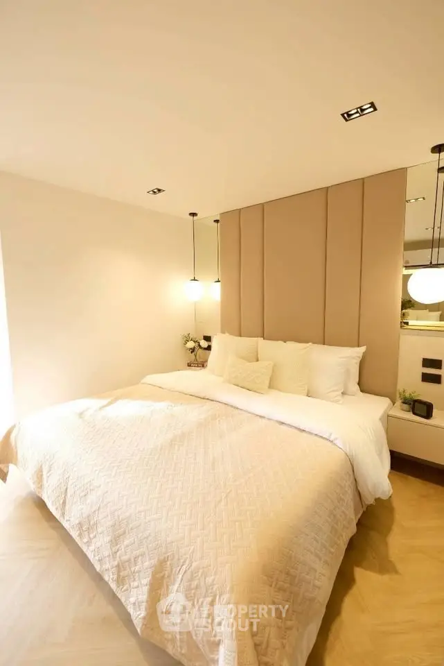 Luxurious bedroom with elegant lighting and plush bedding in modern apartment