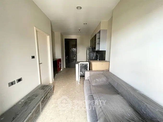 Modern living room with sleek furniture and open kitchen layout in a contemporary apartment.