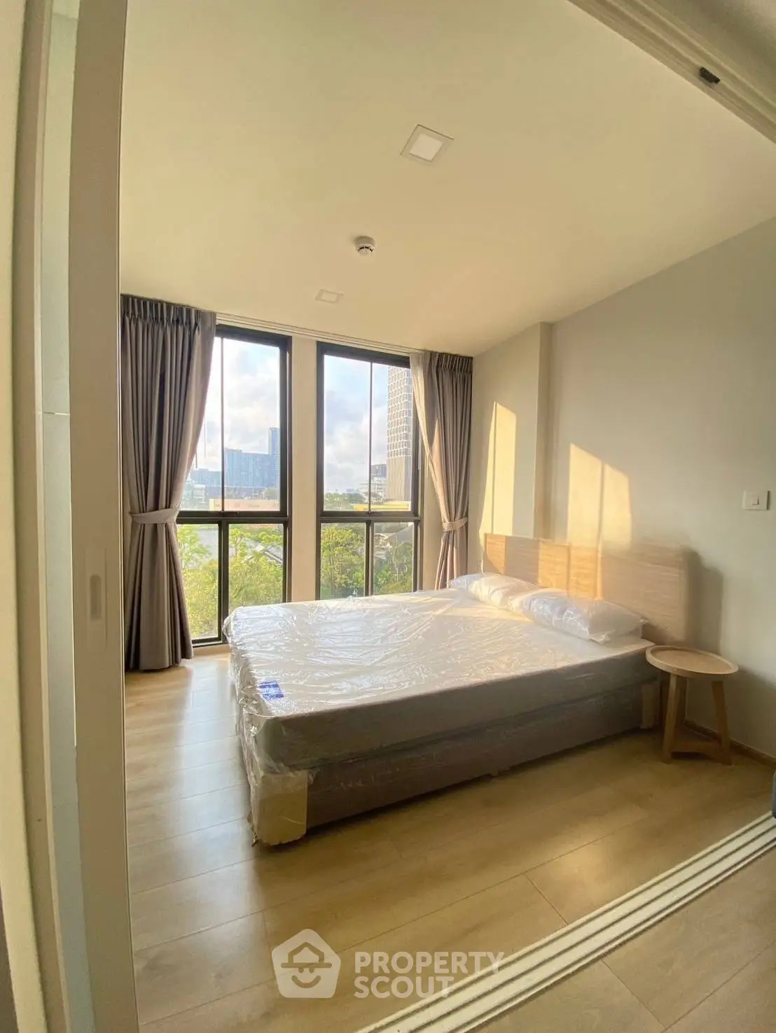 Bright bedroom with large windows and scenic view in modern apartment