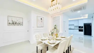 Luxurious dining area with elegant chandelier and modern kitchen in open layout