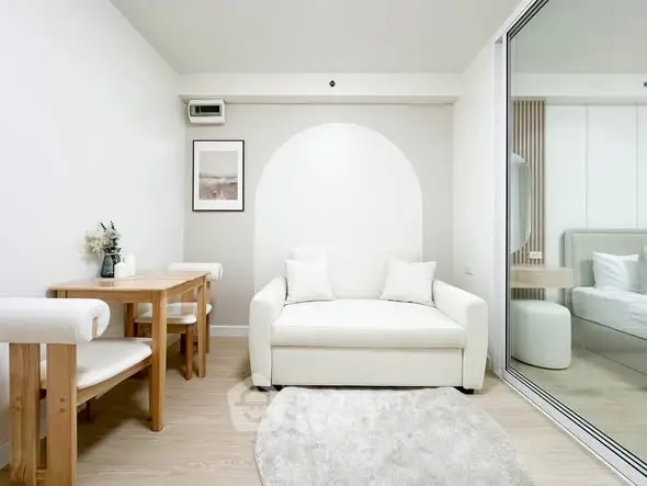 Modern living room with white sofa and dining area in stylish apartment