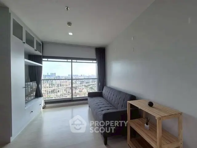 Modern living room with city view, featuring sleek furniture and large windows.