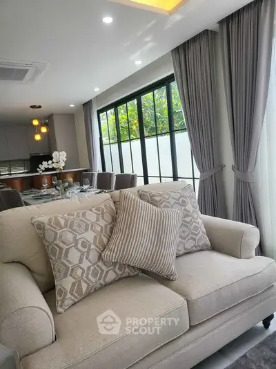 Elegant living room with plush sofa and large windows in modern home