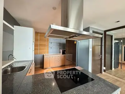 Modern kitchen with sleek design and open layout featuring an island and stainless steel appliances.