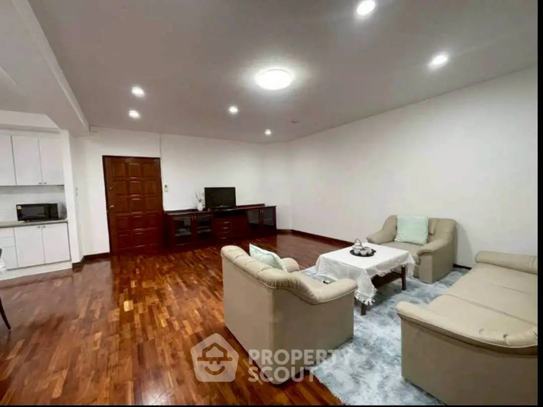 Spacious living room with elegant hardwood flooring and cozy seating area.