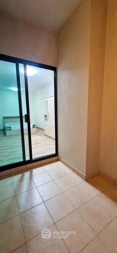 Spacious bedroom with sliding glass doors and tiled flooring, perfect for modern living.