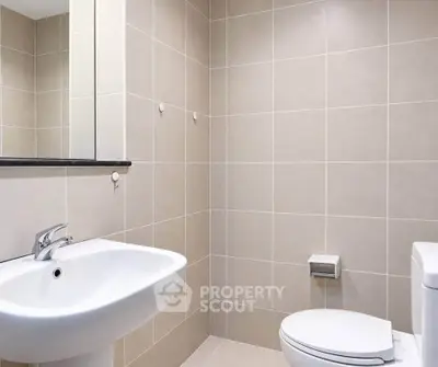 Modern bathroom with sleek fixtures and neutral tile design.