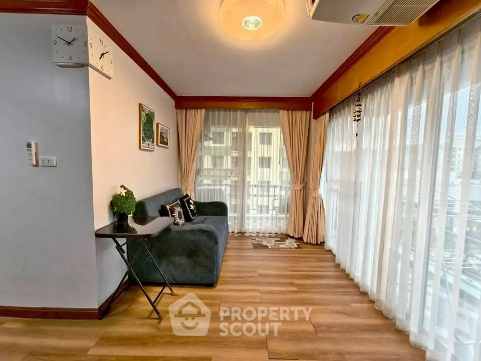 Spacious living room with large windows and elegant decor, perfect for relaxation and entertaining.