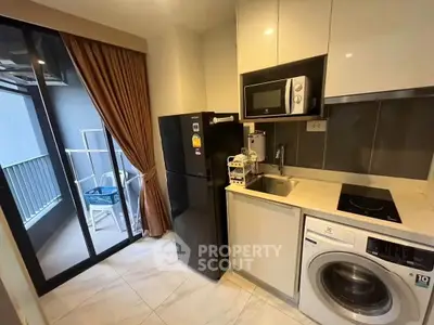 Modern kitchen with appliances and balcony access in a stylish apartment.
