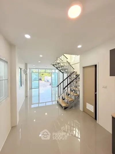 Modern interior with sleek staircase and glossy flooring, perfect for contemporary living.