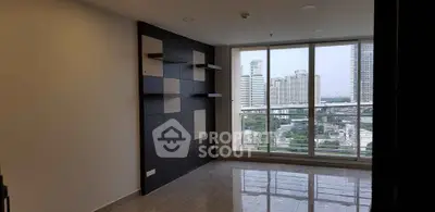 Spacious modern living room with large windows offering stunning city views in a high-rise apartment.