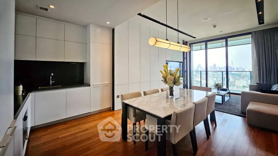 Luxurious modern dining area with city view, featuring elegant marble table and open kitchen layout.