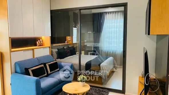 Modern studio apartment with cozy living area and glass partitioned bedroom.