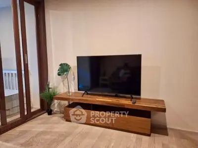 Modern living room with sleek TV stand and large flat-screen TV, perfect for entertainment.