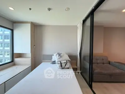 Modern studio apartment with sliding glass partition and cozy furnishings