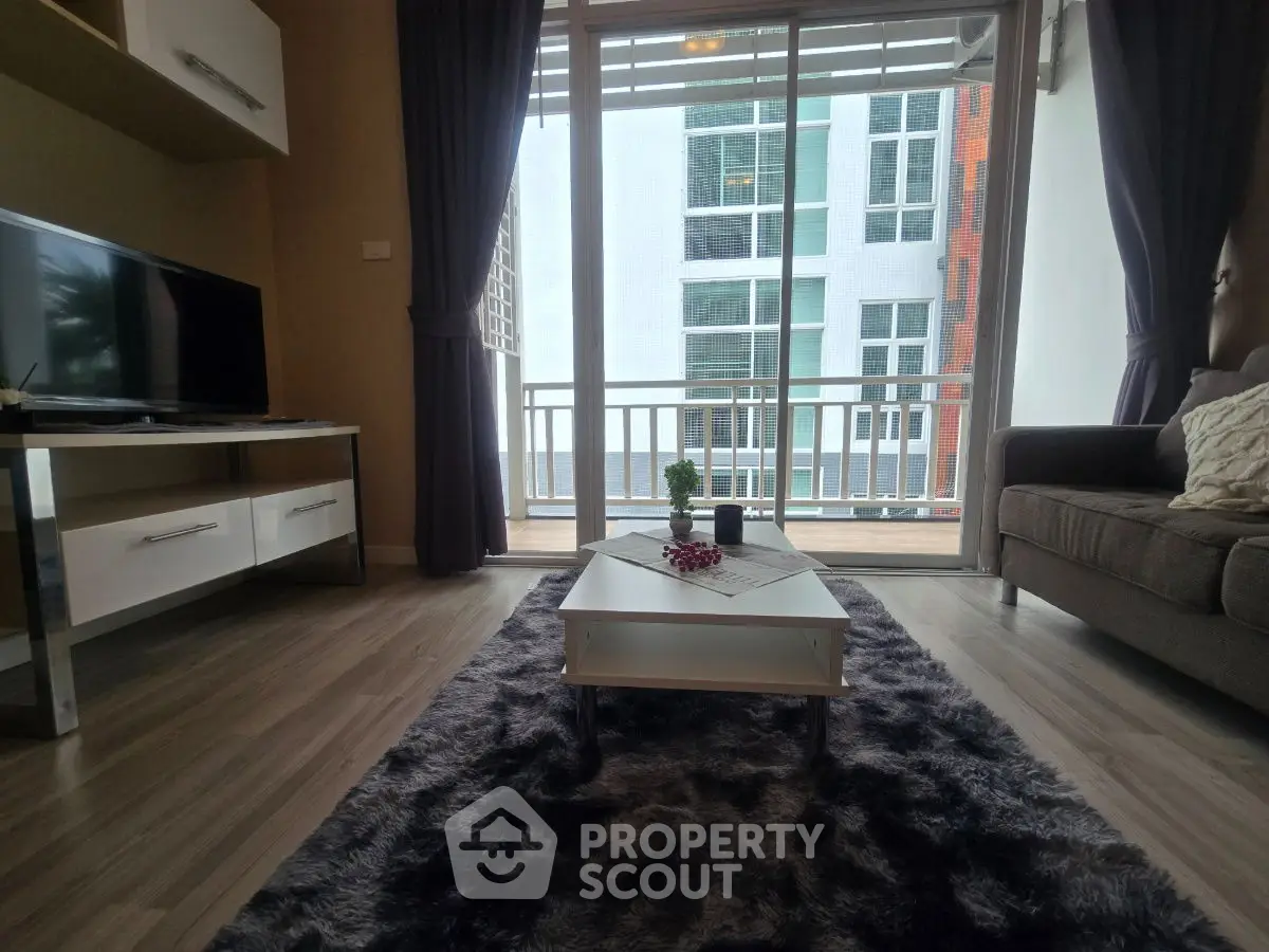 Modern living room with balcony view, stylish decor and cozy ambiance.