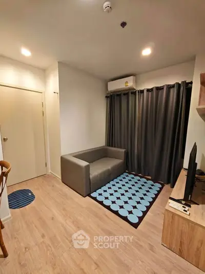 Cozy living room with modern decor and natural light, featuring a stylish sofa and TV setup.