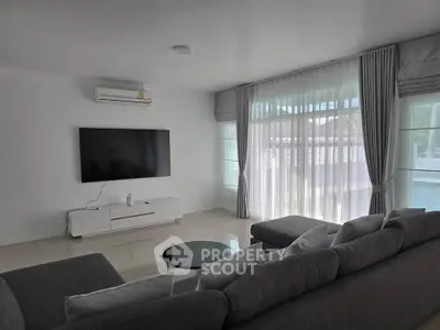 Spacious modern living room with large TV and cozy gray sofa