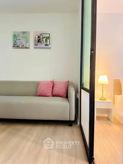 Modern living room with sleek sofa and cozy bedroom view, perfect for stylish urban living.