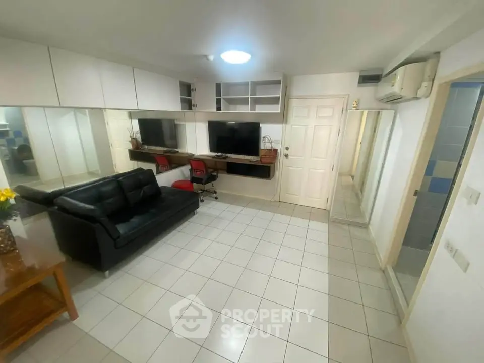 Spacious living room with modern furniture and wall-mounted TV in a stylish apartment.