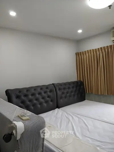 Cozy bedroom with elegant tufted headboard and warm lighting, perfect for relaxation.