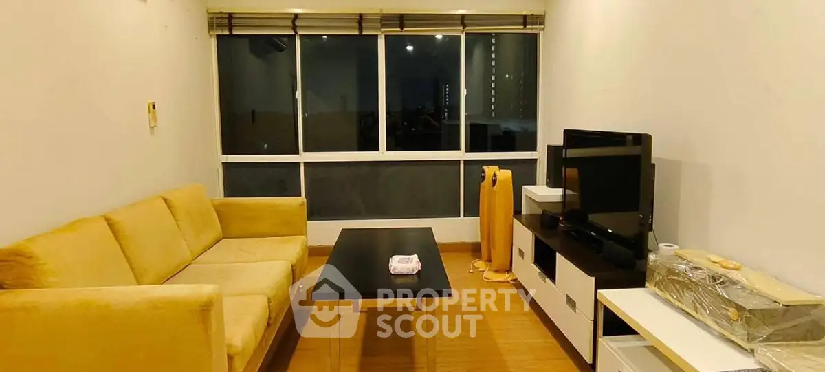 Cozy living room with yellow sofa and large window view