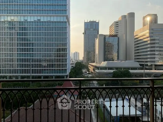Stunning cityscape view from a balcony with modern skyscrapers at sunset.