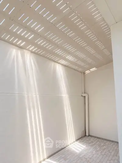 Bright and airy outdoor space with modern design and tiled flooring, perfect for relaxation.