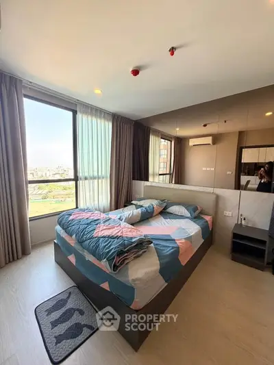 Modern bedroom with large windows and stylish decor in a high-rise apartment.