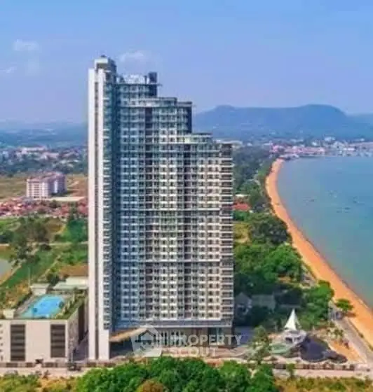 Stunning beachfront high-rise building with panoramic ocean views and lush surroundings.