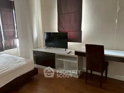 Modern bedroom with sleek TV setup and stylish desk, perfect for relaxation and work.