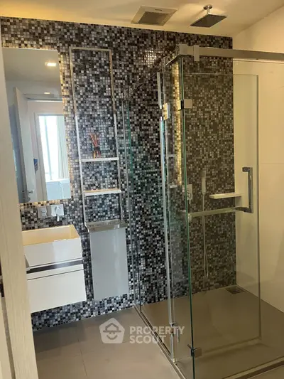 Modern bathroom with glass shower and mosaic tile wall