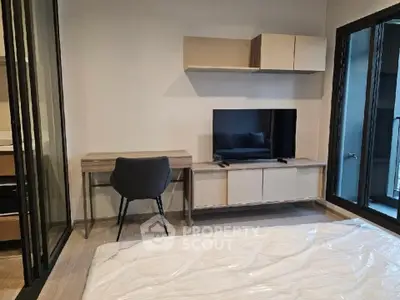 Modern bedroom with sleek furniture and large windows offering natural light.