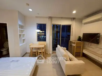 Modern living room with dining area and balcony access in a stylish apartment.