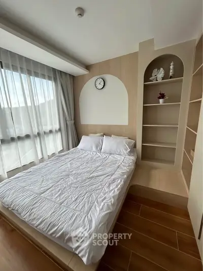 Modern bedroom with cozy bed, stylish shelving, and large window for natural light.