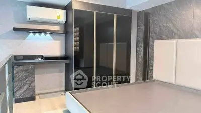 Modern bedroom with sleek design, featuring built-in wardrobe and air conditioning unit.