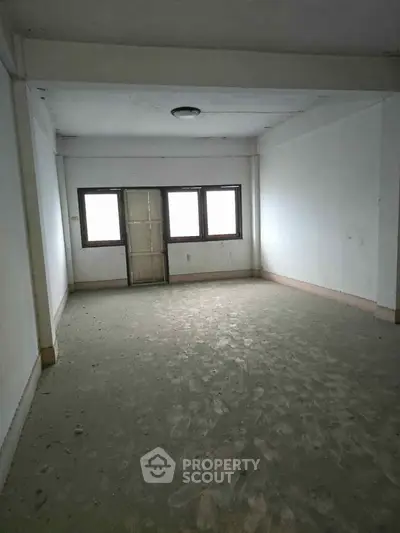 Spacious empty room with large windows and natural light, ideal for customization.