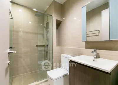 Modern bathroom with glass shower and sleek fixtures in a contemporary home.