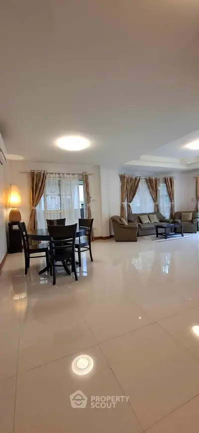 Spacious living room with elegant furnishings and large windows for natural light.