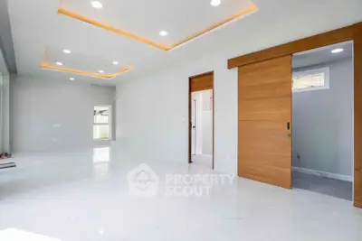 Spacious modern living room with sliding wooden doors and recessed lighting.