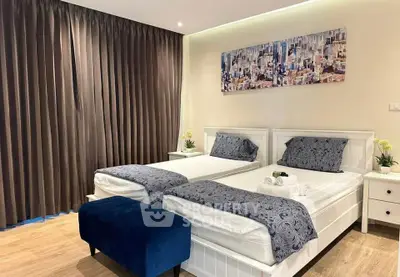 Modern twin bedroom with stylish decor and cityscape artwork, featuring elegant furnishings and cozy ambiance.
