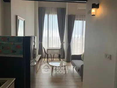 Modern living room with large windows, stylish furniture, and natural light.