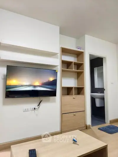 Modern living room with wall-mounted TV and sleek wooden shelving, perfect for cozy urban living.