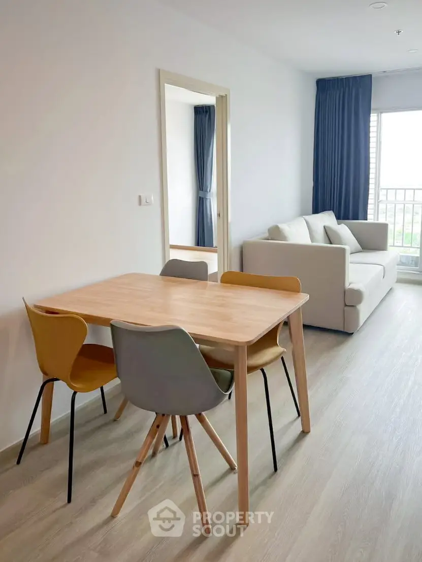Modern living room with dining area and balcony view in a stylish apartment.