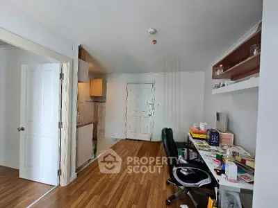 Spacious study area with wooden flooring and built-in shelves in modern apartment