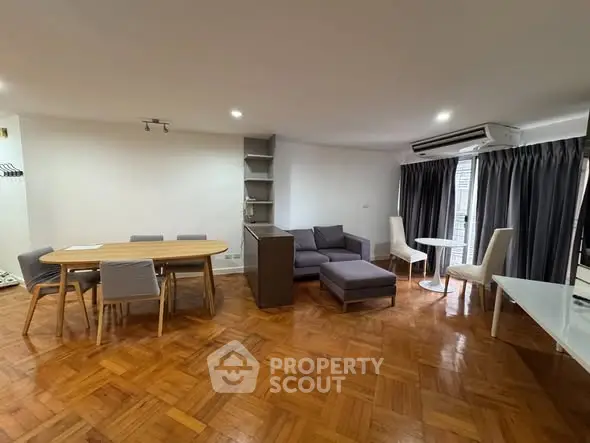 Spacious living room with modern furniture and parquet flooring in a stylish apartment.